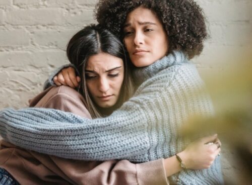 How to Support a Loved One Struggling with Depression Woman holding her hands on her husband's shoulders and trying to support a loved one struggling with depression