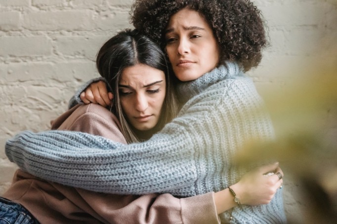 How to Support a Loved One Struggling with Depression Woman holding her hands on her husband's shoulders and trying to support a loved one struggling with depression