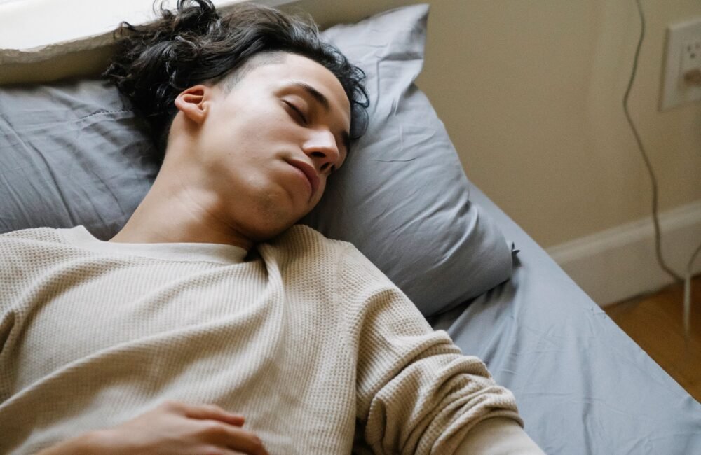 Person sleeping beside a smartphone and smartwatch used for sleep tracking