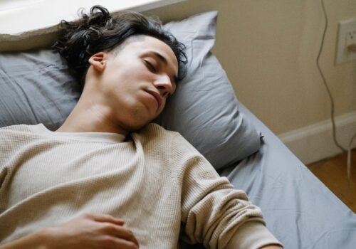 Person sleeping beside a smartphone and smartwatch used for sleep tracking