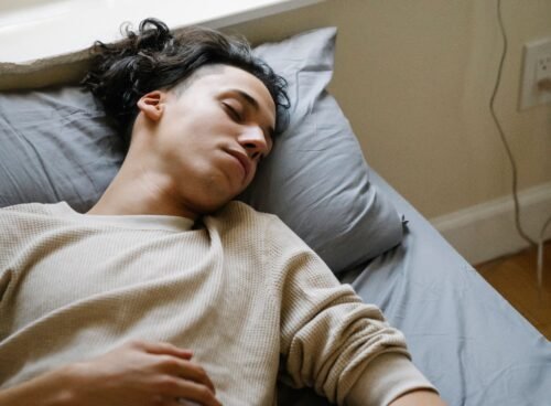 Person sleeping beside a smartphone and smartwatch used for sleep tracking