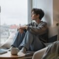 A person sitting thoughtfully by a window during a quiet weekend morning